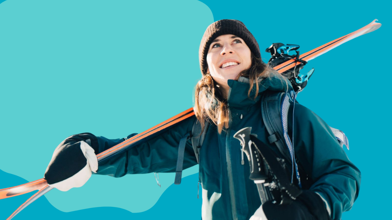 Person holding skis against a blue background